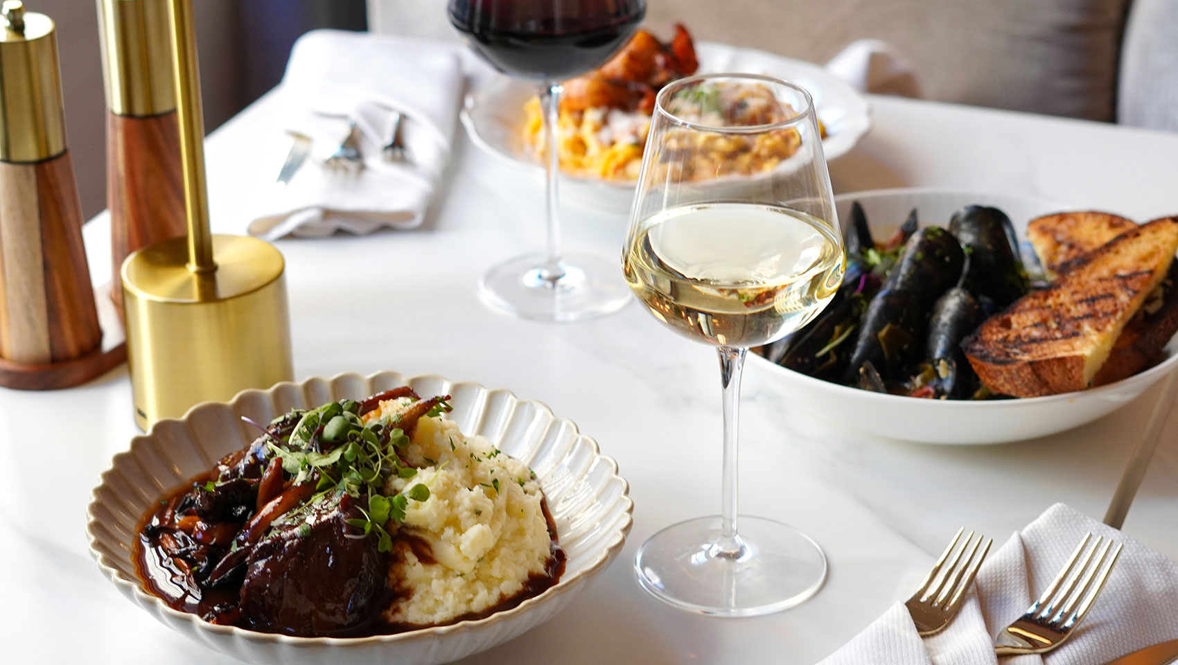Plates of food and glasses of wine on table at Serliana